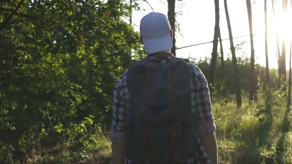 A Young Man Walks in the Woods.