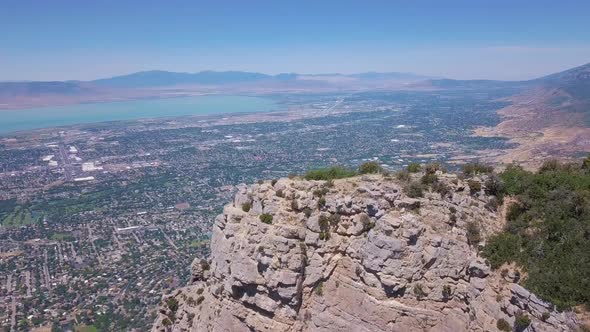 180 degree drone shot of American flag waving in the wind overlooking Provo Utah alt