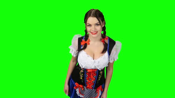 Girl in Bavarian Costume Shows Thumb Up. Green Screen. View From Above alt