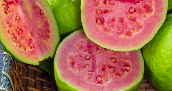 closeup on red guavas cut in basket alt