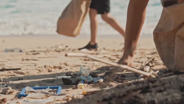 Volunteer Raises and Throws a Plastic Bottle Into the Garbage Eco Bag alt