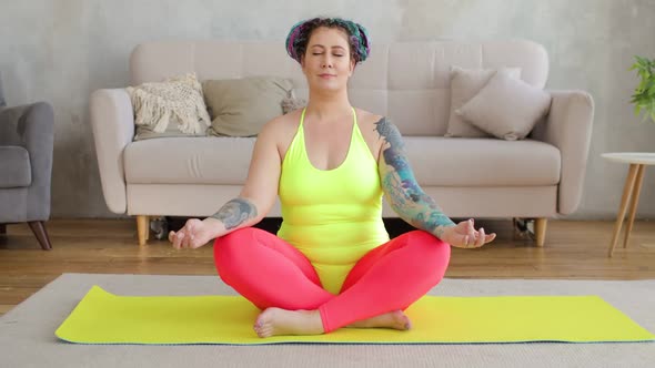 Woman Newcomer in Sport Are Doing Meditation Sitting on Yoga Mat in Living Room