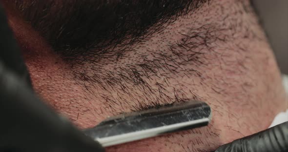 Shaving with a Dangerous Razor. Close-up. alt