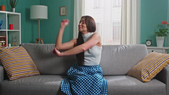 Woman Is Sitting On Sofa In Living Room and Dancing alt