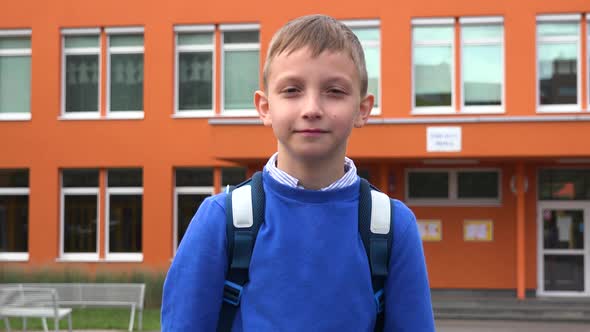 A Young Boy Smiles and Extends His Hand To the Camera for a Handshake - an Elementary School alt