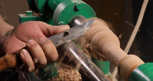 Closeup of carpenter turning wood on a lathe alt