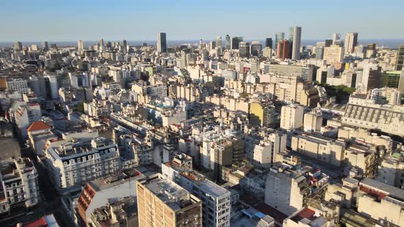 Aerial pan right of Monserrat neighborhood buildings, tree-lined Avenida de Mayo and Barolo Palace a alt
