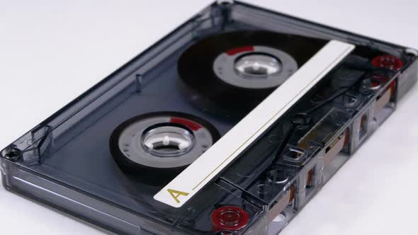 Transparent Audio Cassette Rotates on White Background alt