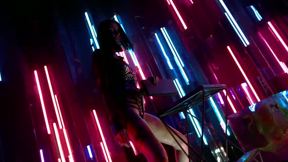 Passionate Young Woman Posing on the Background Wall with Colorful Neon Lights on Stage. She's alt