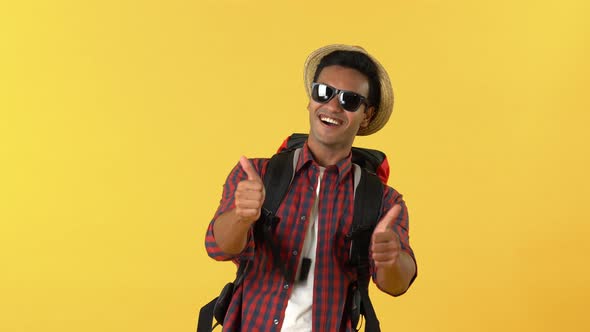 Surprised male Indian tourist backpacker smiling and giving thumbs up