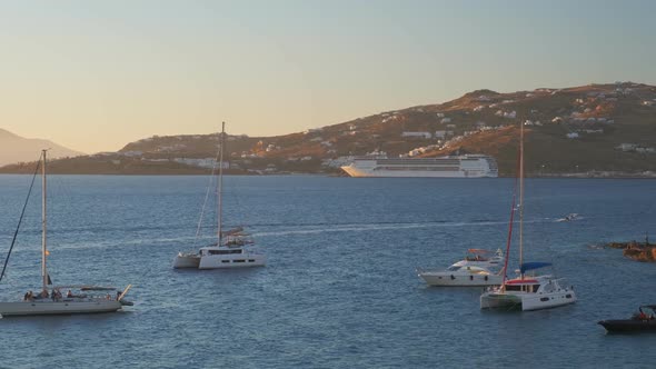 Sunset in Mykonos, Greece, with Cruise Ships and Yachts in the Harbor alt