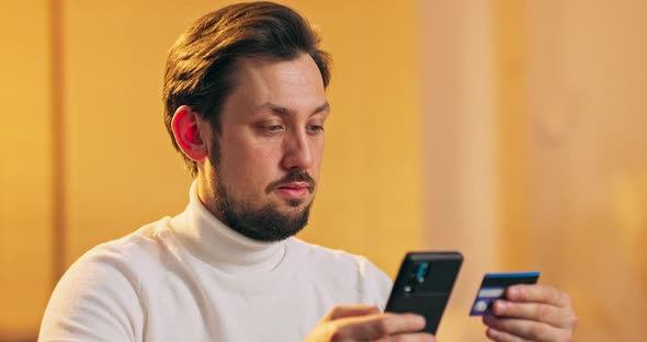 Middle Aged Man in Wheelchair Holding Credit Card and Using Cell Phone Shopping and Online alt