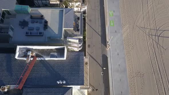 Slow motion beach houses at Santa Monica Pier.Dramatic aerial view flight bird's eye view tilt up d alt
