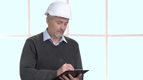 Serious Architect Writing on Clipboard. alt