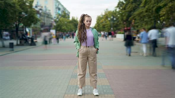 Time Lapse Portrait of Attractive Young Woman with Dreads Standing in Busy Pedestrian Street alt
