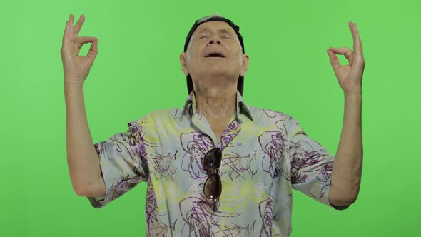 Senior Man Tourist in Colorful Shirt Doing Meditation. Handsome Old Man alt