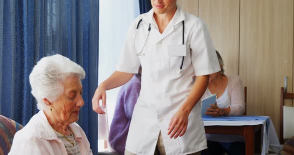 Female doctor interacting with senior woman alt