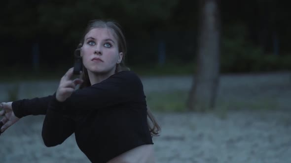 Cute Confident Girl Performing a Show with Flame Standing in the Forest or Park alt