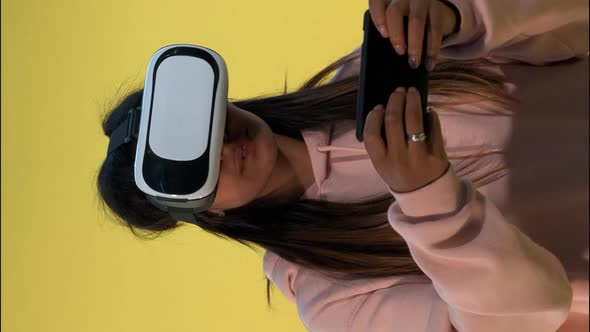 Multiracial Girl in Virtual Reality Glasses Playing Online Games on Smartphone alt