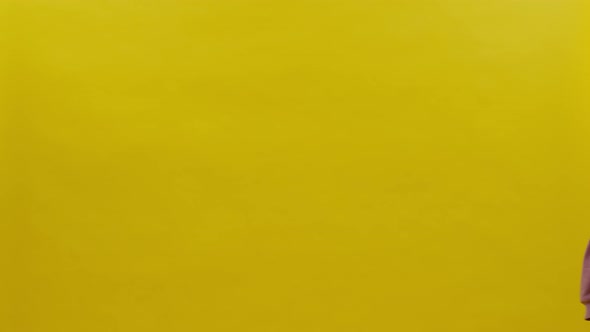 Elderly Man And Woman Come Into Frame On Yellow Background alt