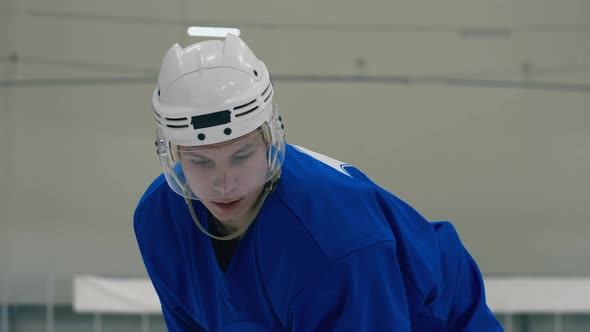 Ice hockey player throwing puck up with stick