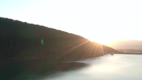 Aerial shot, Frumoasa Dam Romania with bright sunset and lens flare alt