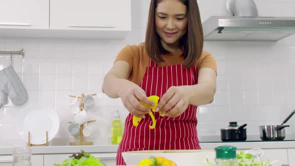 Young Asian woman cooking in kitchen at home. The wife is cooking a special meal for her husband. alt