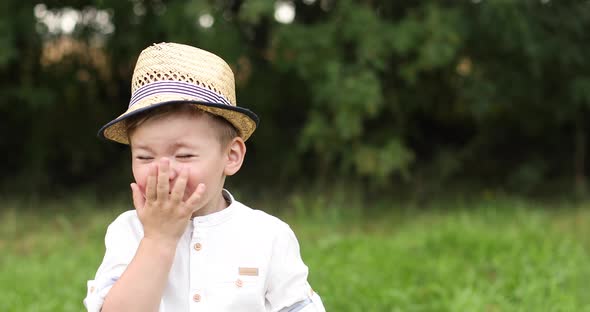 Smiling Shy Caucasian Child in a Straw Hat Looking Ahead