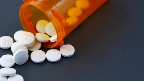 White Color Medical Pills Spilling on Black Background alt