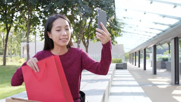 Woman taking selfie on cellphone in the park  alt