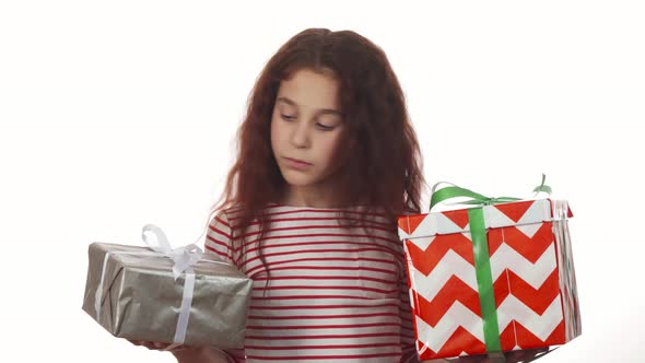 A Thoughtful Girl Looks at Her Two Gifts and Chooses Among Them