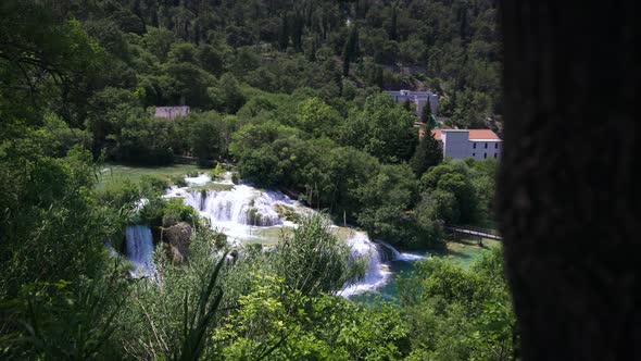 Forest, waterfalls and houses in Krka National Park, Croatia, wide pan alt