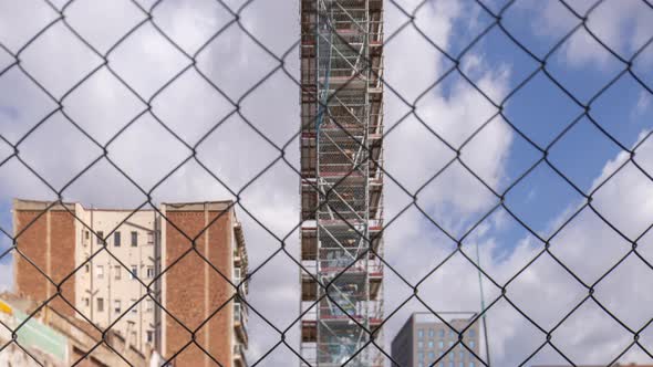 Construction Site with Clouds Behind Wire Fence alt