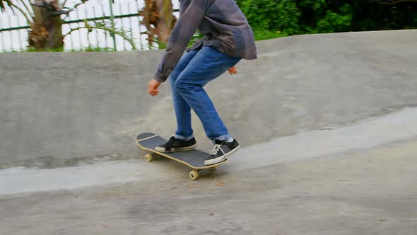 Front view of young caucasian man practicing skateboarding on ramp in skateboard park 4k alt