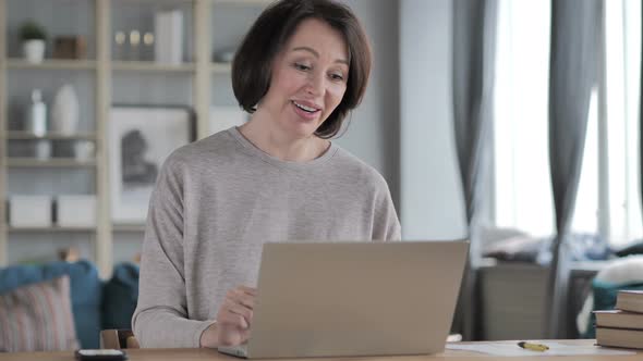 Online Video Chat on Laptop at Work By Senior Woman alt