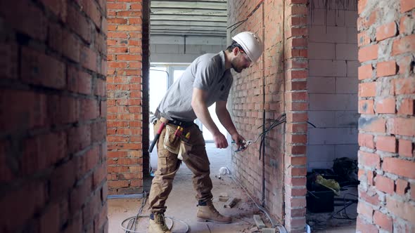 Worker is cutting wires with lineman's pliers.