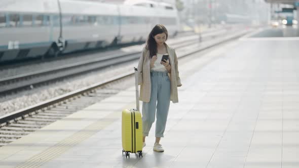 Portrait of Young Woman with Suitcase Standing on Platform alt