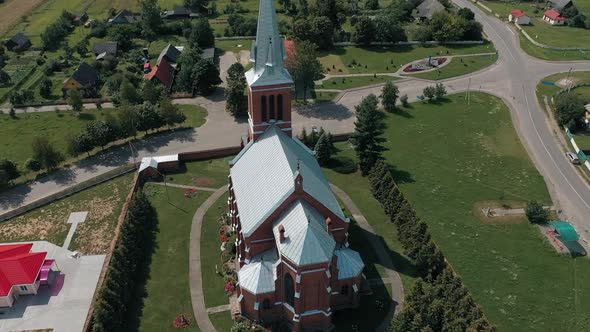Drone Flies Around Gothic Church Amid Picturesque Countryside in Belarus