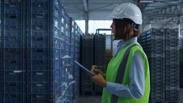 Female Warehouse Worker Checking Shipment Boxes Inspecting Delivery Package alt