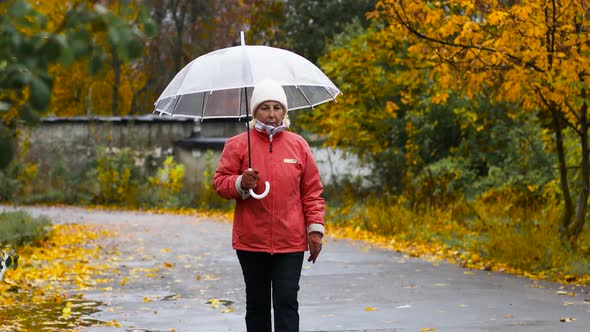 Adult Woman in a Red Jacket and Under a Transparent Umbrella Enjoying the Rainy Weather
