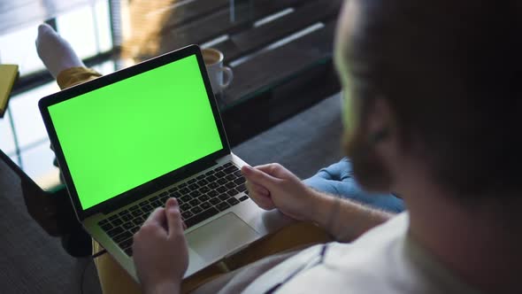 Unrecognizable Bearded Male Video Calling on Laptop with Green Screen alt