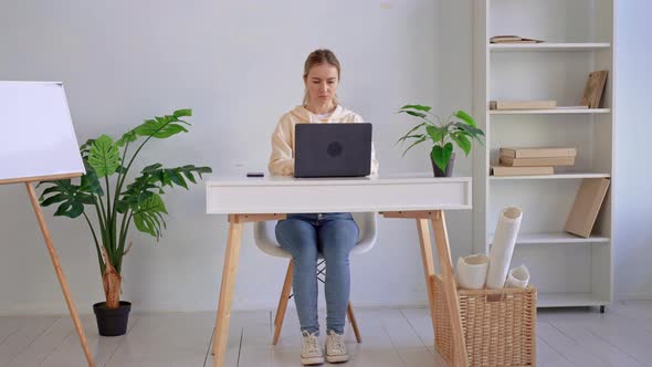 Young Caucasian Woman Typing on Laptop alt