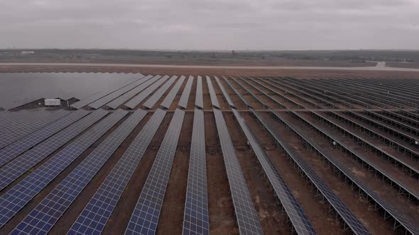 Aerial Drone View Into Large Solar Panels at a Solar Farm at Cloudy Autumn Day. Solar Cell Power alt