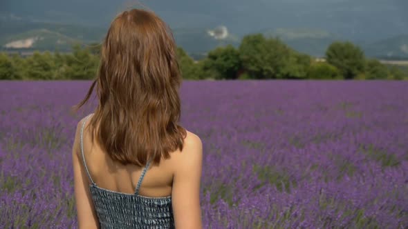 Portrait of young woman standing in lavender field in southern France