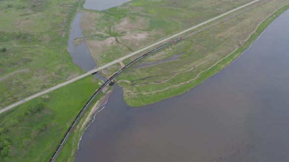 A Drone View of a Freight Train Driven By a Diesel Locomotive on a Railroad alt