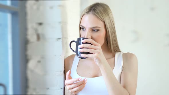 Medium Closeup Pensive Young European Woman Looking on Window at White Loft Interior alt
