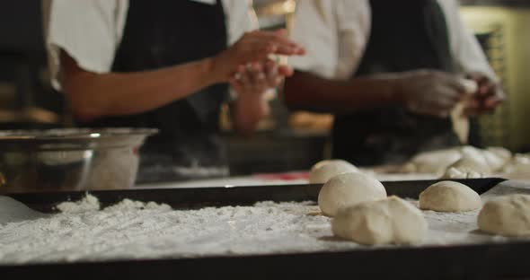 Animation of hands of diverse male and female bakers preparing rolls alt