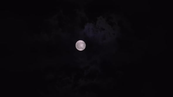 Bright Full Moon Behind Fast Moving Dark Clouds on Night Sky alt