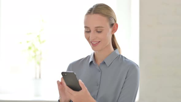 Woman Celebrating Online Success on Smartphone alt