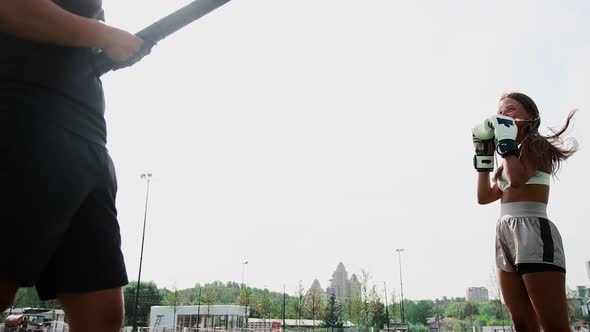 Boxing Training  Young Woman Training the Kick on the Target in Her Coaches Hand alt
